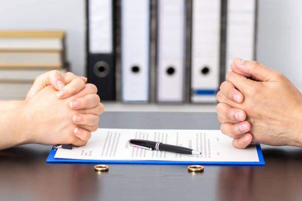 esposa y esposo firmando el divorcio - dividing fotografías e imágenes de stock