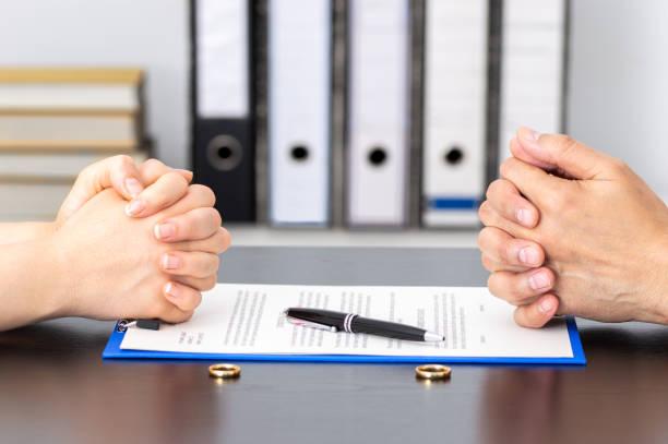 wife and husband signing divorce Hands of wife and husband signing divorce documents or premarital agreement at the lawyer's office dividing stock pictures, royalty-free photos & images
