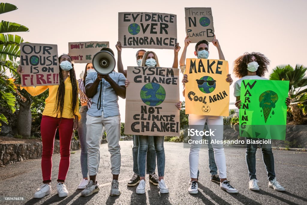 Group of activists protesting for climate change during covid19 - Multiracial people fighting on road holding banners on environments disasters - Global warming concept Climate Change Stock Photo