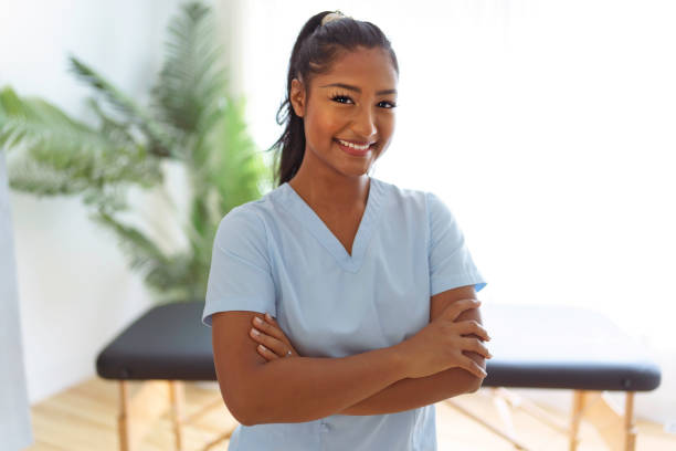 portret młodej fizjoterapeutki w ośrodku fizjoterapii - physical therapy arms crossed smiling women zdjęcia i obrazy z banku zdjęć