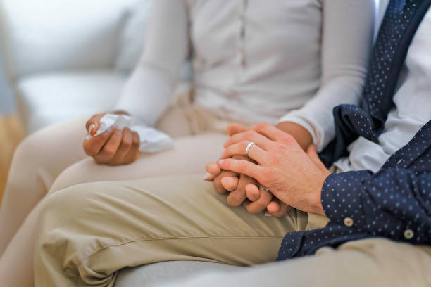 mano che tiene tissu di una coppia sedersi sul divano - wife husband discussion couple foto e immagini stock