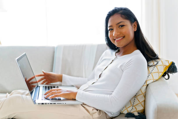 istock Young woman using her laptop on cosy sofa at home 1351477409