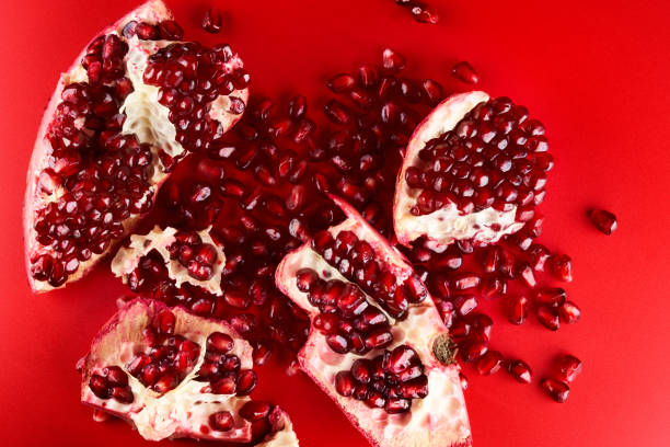 istock Ruby ripe fresh juicy sliced pomegranate isolated on red background 1351478215
