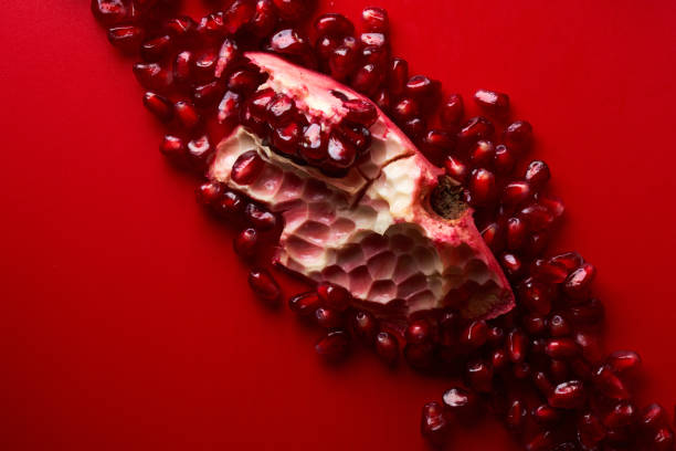 istock Ruby ripe fresh juicy sliced pomegranate isolated on red background 1351478249