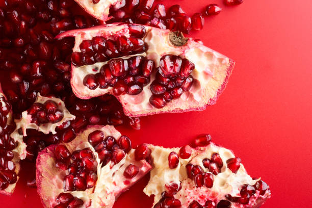 istock Ruby ripe fresh juicy sliced pomegranate isolated on red background 1351478810