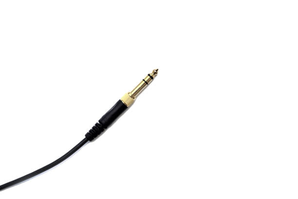 istock Stereo audio headphone jack with cable on white background. Gold jack plug for connecting audio devices and musical instruments. 1351479469