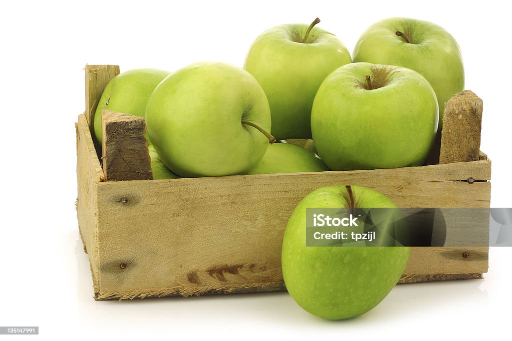 freshly harvested "Granny Smith" apples in a wooden crate freshly harvested "Granny Smith" apples in a wooden crate on a white background Apple - Fruit Stock Photo