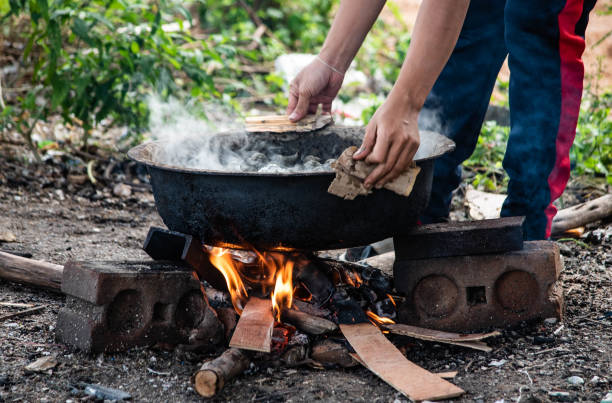 istock A fisherman is boiling chisels in a basin using firewood. 1351480433