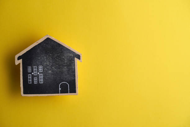 istock wooden model house against yellow background 1351481786