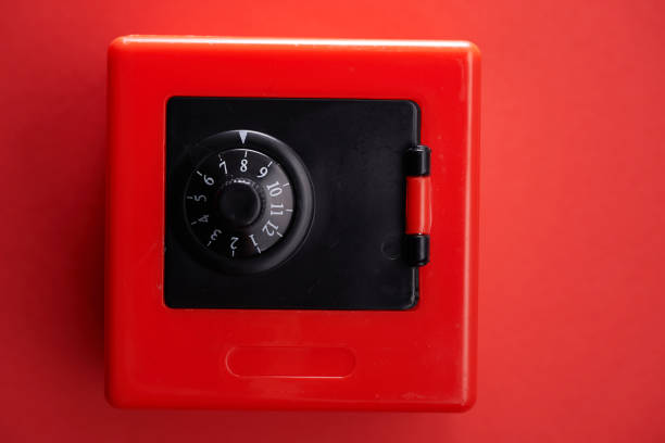 roter mini-safe auf rotem farbhintergrund - coin bank cash box safety deposit box lock stock-fotos und bilder