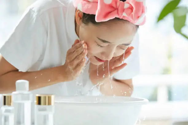 Photo of Young Asian woman washing her face