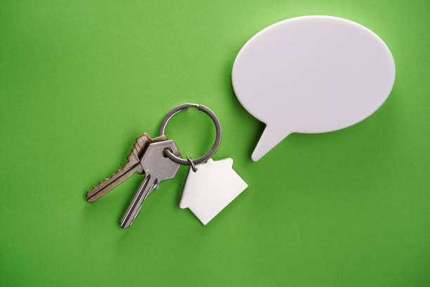 house shaped  key ring with speech bubble  against green background house shaped  key ring with speech bubble  against green background announce stock pictures, royalty-free photos & images