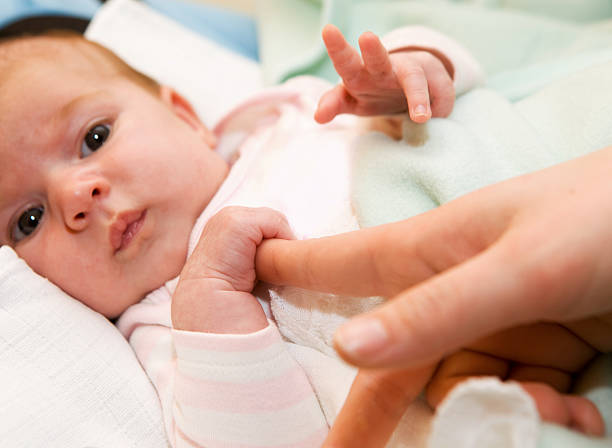 istock Cute newborn baby with his mother's hamd 135148410