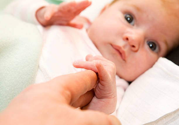istock Cute newborn baby with his mother's hamd 135148412