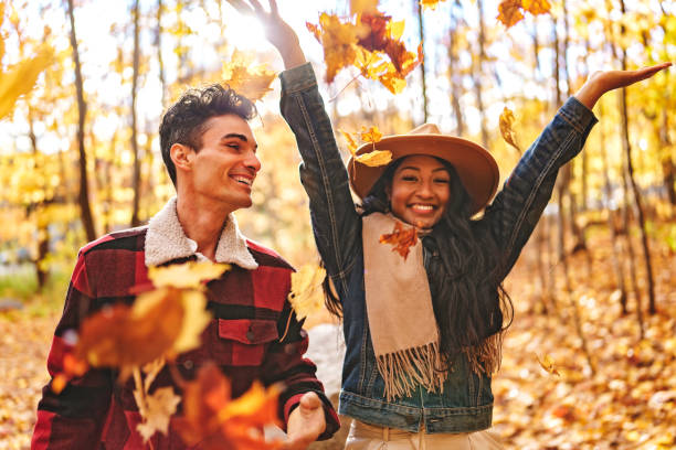 Young beautiful couple in the autumn garden at fall. stock photo