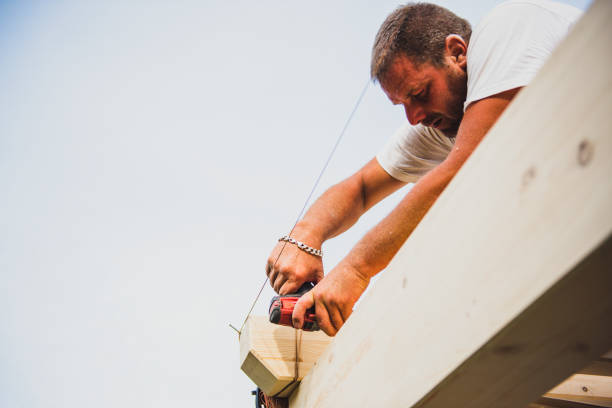 istock Construction worker on the wooden frame of a roof 1351485001