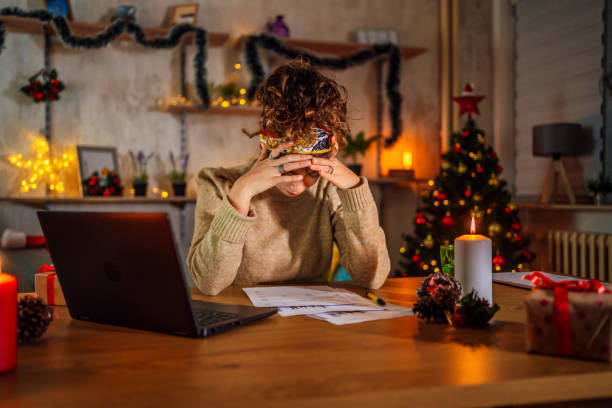 Young overworked woman Exhausted young woman working at home late at night during Christmas holidays Tensed stock pictures, royalty-free photos & images