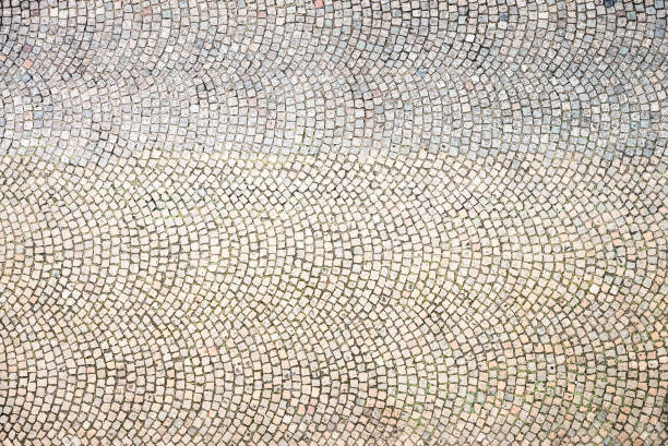 Cobblestones in concentric patterns - directly above A large area of an empty cobblestoned street in Paris, France, photographed from directly above. cobblestone stock pictures, royalty-free photos & images
