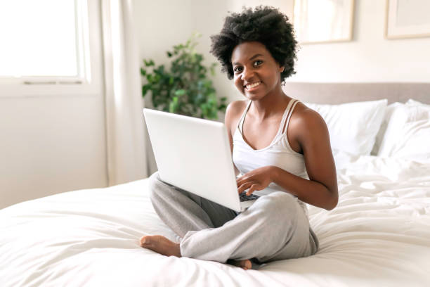 istock young black woman using a laptop in bright bedroom 1351489971