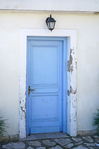 white house facade with traditional greek blue door