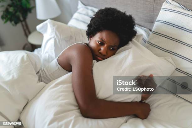 Beautiful Young African Woman In Tank Top Lying In Bed Look Sad With His Pillow Stock Photo - Download Image Now