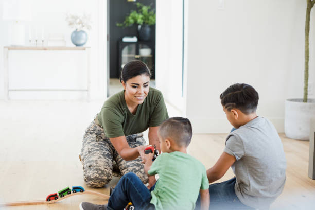 istock Female soldier and sons enjoy playing with train set 1351490461