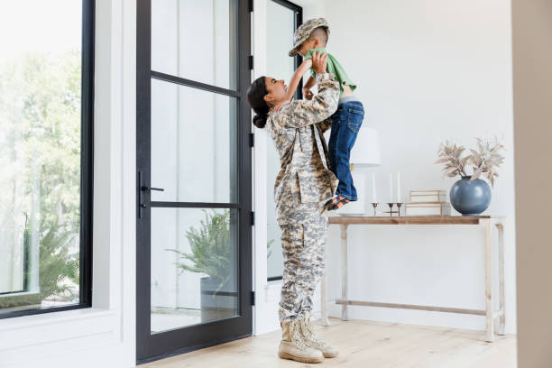 istock Female soldier picks up young son 1351490673