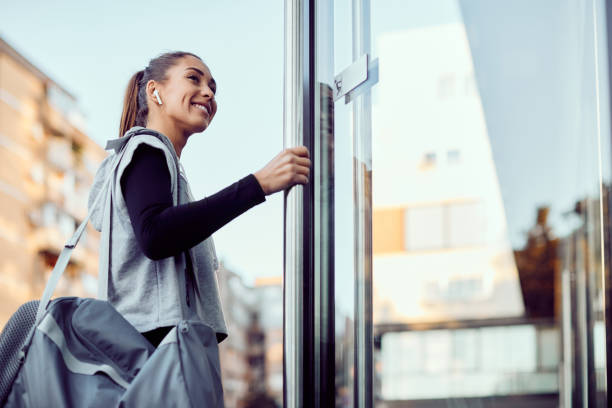 vue ci-dessous d’une femme sportive heureuse entrant dans un gymnase. - entrer photos et images de collection