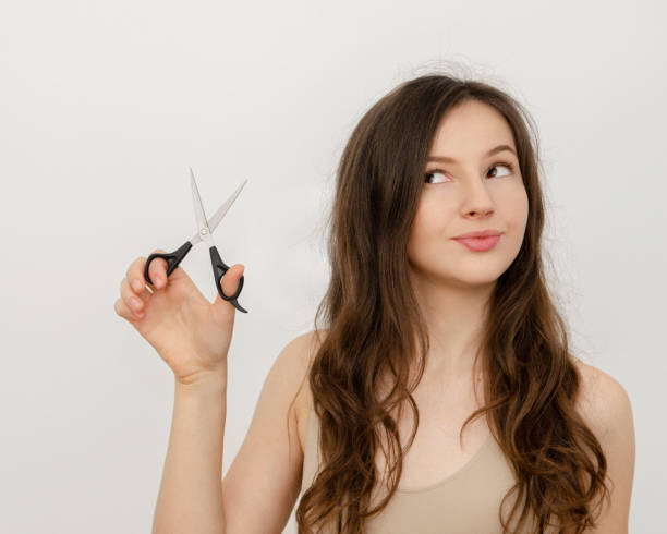 istock a woman with scissors to cut hair 1351498061