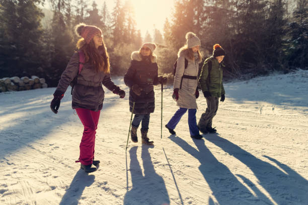famille multigénérationnelle profitant de la randonnée dans la forêt d’hiver. - group of people teenager snow winter photos et images de collection