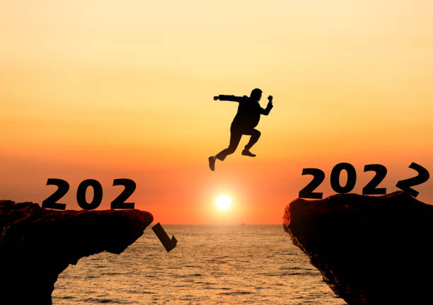 istock Businessman jumping from 2021 cliff to 2022 1351504002