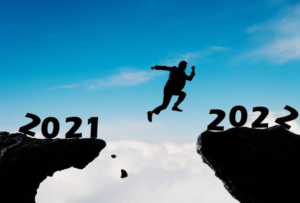 istock Businessman jumping from 2021 cliff to 2022 1351504005