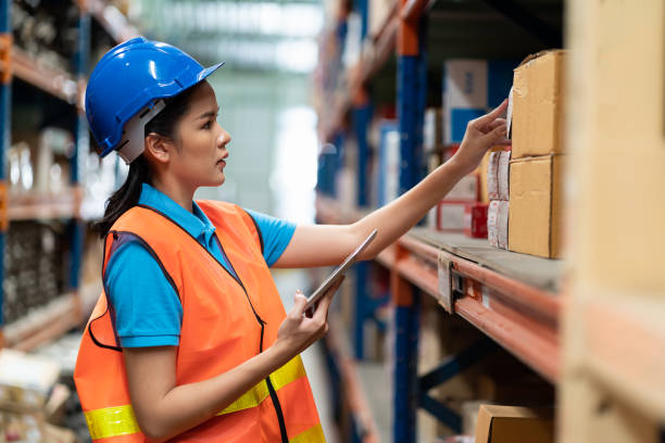 istock Asian woman worker with safety vest and helmet working and using tablet pc computer in automotive spare parts warehouse. people, car service, repair and maintenance concept 1351507350