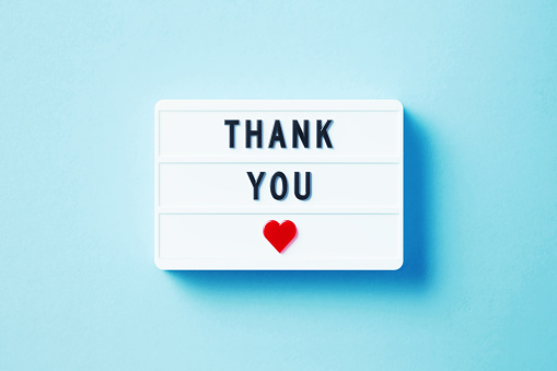 Thank You written white lightbox sitting on blue background. Horizontal composition with copy space.