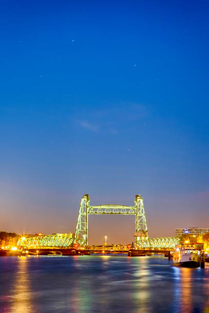 miejsca docelowe w holandii. oświetlony most koninginnebrug w rotterdamie podczas blue hour. pionowa kompozycja obrazu - niderlandy zdjęcia i obrazy z banku zdjęć
