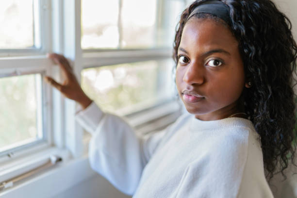 istock black woman looking out window at home 1351514689