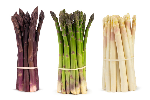 Three bunches of different fresh asparagus isolated on white. Purple white and green asparagus.