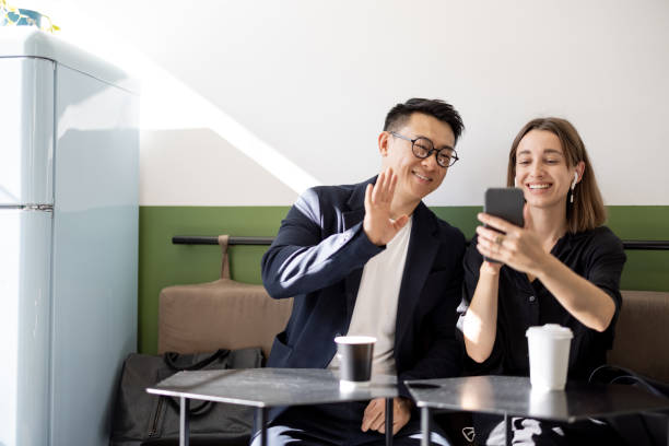 istock Couple having video call on smartphone in cafe 1351518895