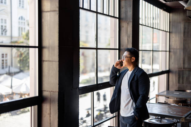 istock Man talk on smartphone and look from window 1351519177