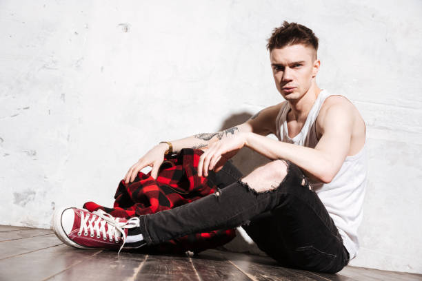 istock Serious man sitting on floor posing 1351520058