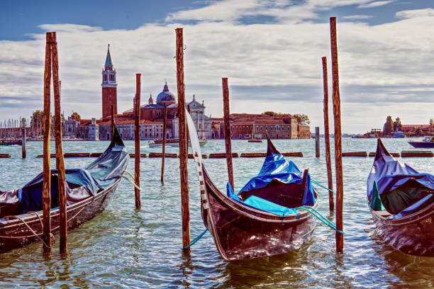 Gondolas moored near St Marks Square, Venice opposite the island of San Giorgio Maggiore Venice Italy - Gondolas bobbing contentedly on the water, moored near St Marks Square, Venice opposite the island of San Giorgio Maggiore san giorgio maggiore stock pictures, royalty-free photos & images