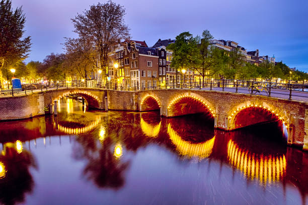 malowniczy pejzaż miejski amterdam z jednym z kanałów. z podświetlanych mostem i tradycyjnymi holenderskimi domami o zmierzchu w tle w amsterdamie.obraz poziomy - niderlandy zdjęcia i obrazy z banku zdjęć