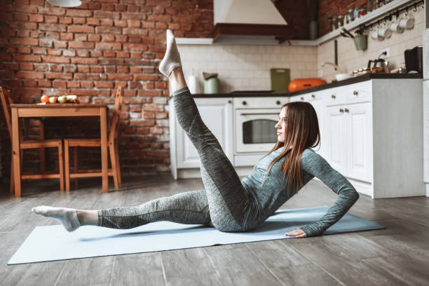 nowoczesna kobieta ćwiczące ćwiczenia izometryczne w domu - gimnastyka izometryczna obrazy zdjęcia i obrazy z banku zdjęć