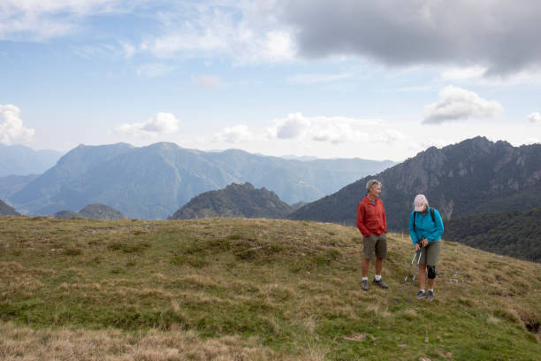 istock Hiking couple relax on grassy mountain ridge, in fall 1351532257