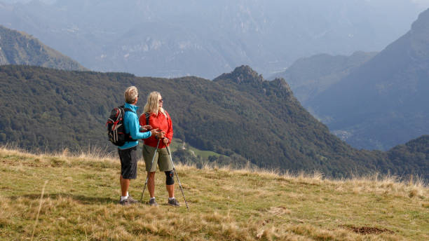 istock Hiking couple relax on grassy mountain ridge, in fall 1351532484