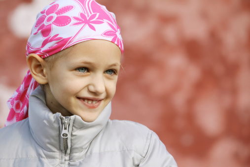 beautiful caucasian girl wearing a head scarf due to hair loss from chemotherapy fighting cancer