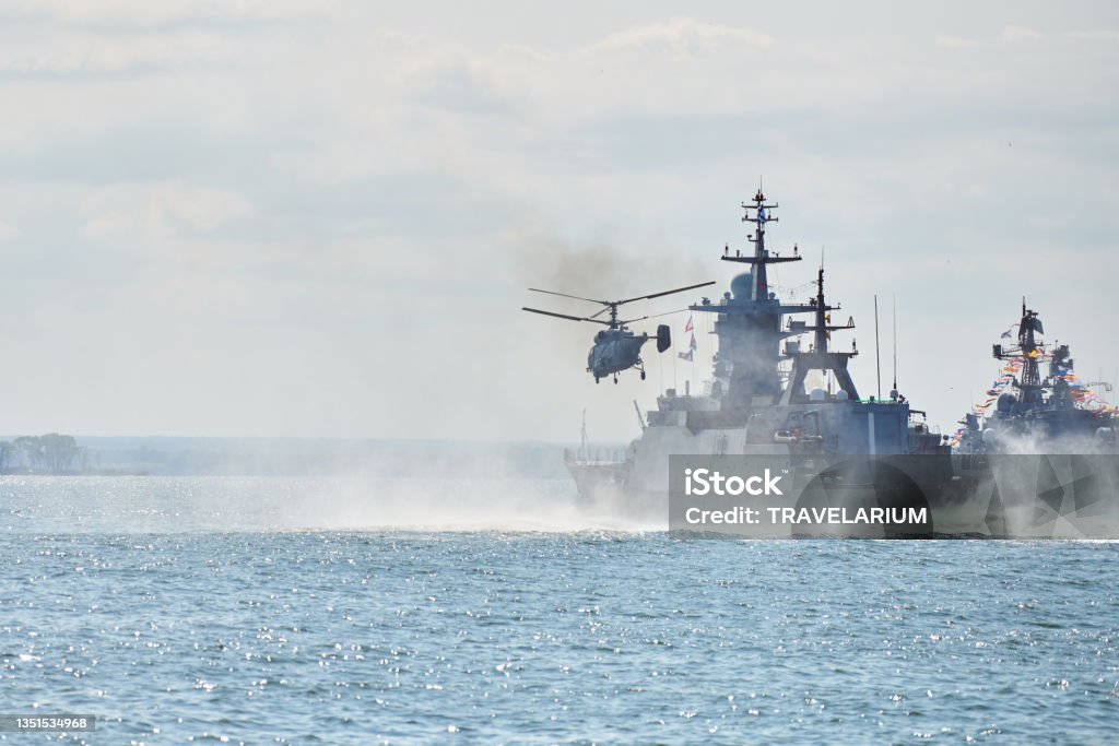 Battleships war ships corvette during naval exercises and helicopter maneuvering over sea, warships Battleships war ships corvette during naval exercises and helicopter maneuvering over water in Baltic Sea. Warships, helicopters and boats perform tasks in sea, military warships sailing, Russian Navy Navy Stock Photo