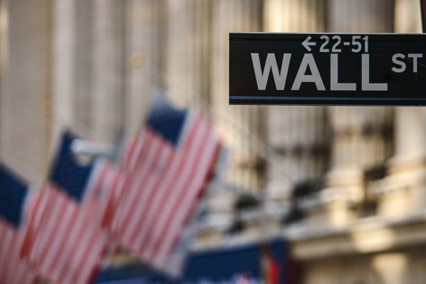 Wall Street sign post in front of Stock Exchange building in New York, USA stock photo