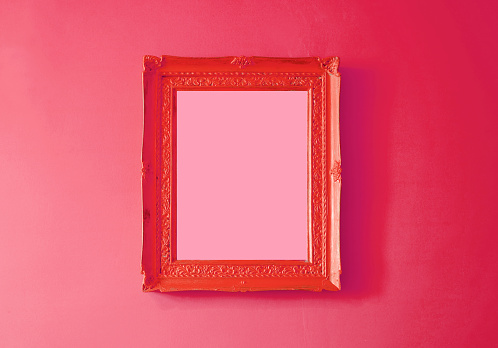 Scarlet red antique empty photo frame isolated on gradient raspberry red colored wall