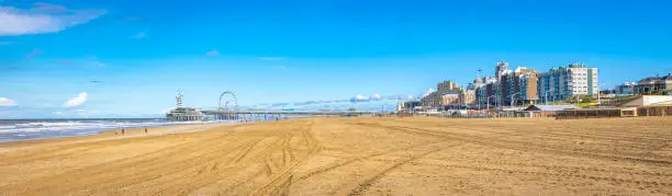 Panoramic view of buildings and the famous pier at the beach in Scheveningen, close to the city of The Hague, Holland.